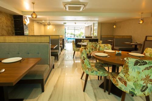 a dining room with tables and chairs in a restaurant at Nova Candolim By Sudhanand, Candolim in Candolim