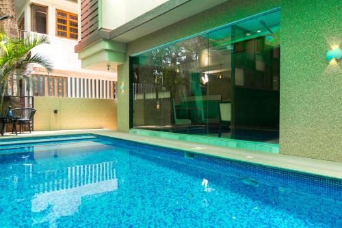 a swimming pool in front of a building at Nova Candolim By Sudhanand, Candolim in Candolim