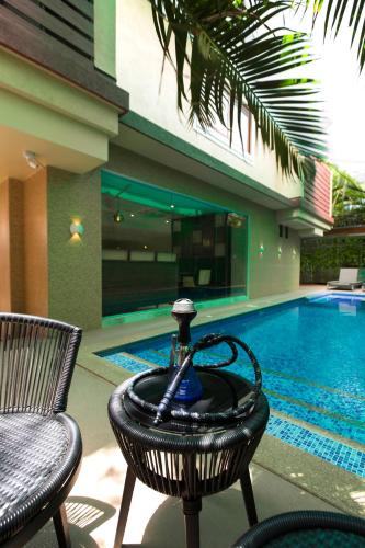 a pool with a table and two chairs and a fountain at Nova Candolim By Sudhanand, Candolim in Candolim