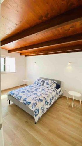 een slaapkamer met een bed en een houten plafond bij Casa branca in Olhão