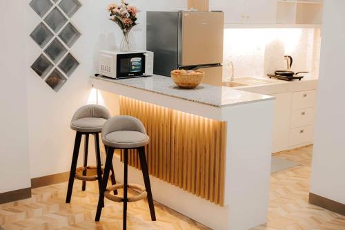 une cuisine avec un comptoir avec des tabourets et un four micro-ondes dans l'établissement A’s Penthouse - Calbayog, à Calbayog
