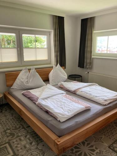 2 Betten in einem Schlafzimmer mit 2 Fenstern in der Unterkunft Nesterl in Schladming