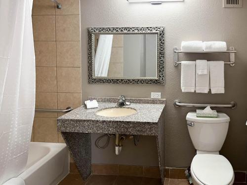 ein Badezimmer mit einem Waschbecken, einem WC und einem Spiegel in der Unterkunft Studio 6 Nacogdoches TX SFA University in Nacogdoches