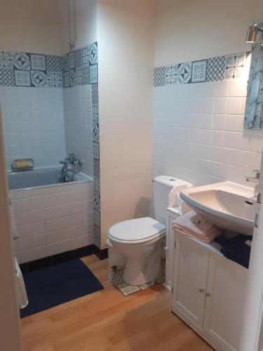 une salle de bain avec toilettes, lavabo et baignoire dans l'établissement L'échappée blésoise, à Blois