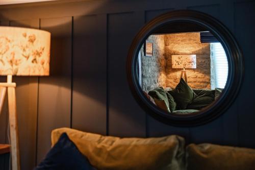 a living room with a mirror and a couch at Spacious, luxury town centre Granary conversion in Stamford