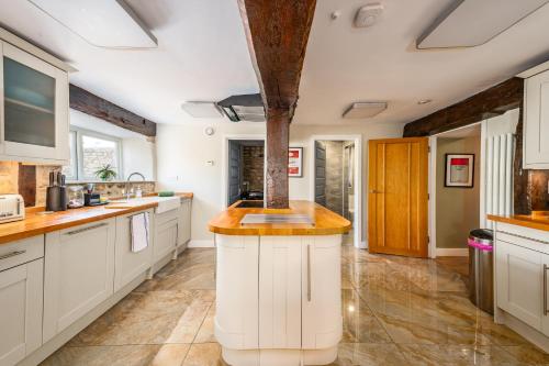 a kitchen with white cabinets and a large island at Spacious, luxury town centre Granary conversion in Stamford