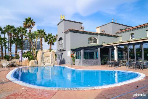 a large blue swimming pool in front of a building at Hotelet elRetiro in Cambrils