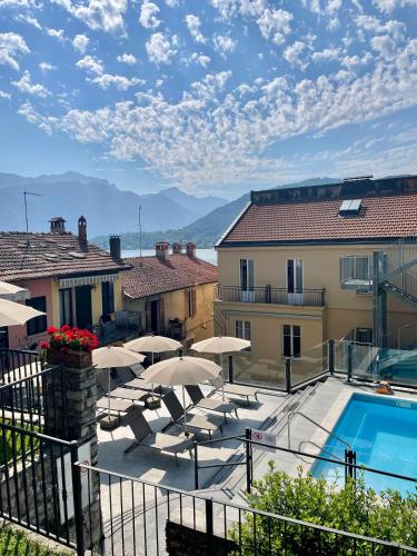 a patio with umbrellas and a pool and buildings at Hotel Bazzoni in Tremezzo