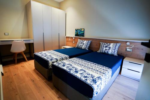 a bedroom with two beds and a cabinet at Klei’s Daily Apartment in Tirana