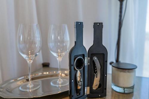 two wine glasses are next to a bottle of wine at Las Magnolias Bodega Boutique in Gualeguaychú