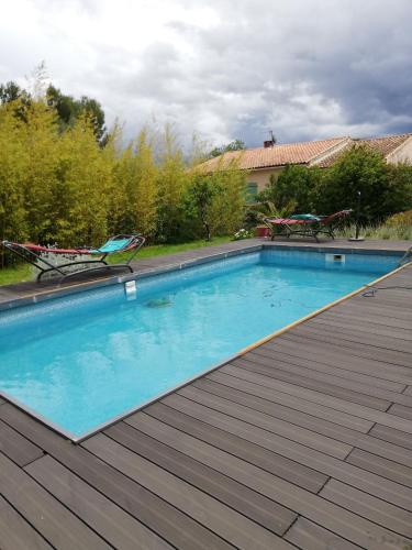 une grande piscine avec une terrasse en bois dans l'établissement UN AVANT GOUT DU NIRVANA, à Canet