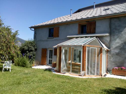 ein Gewächshaus vor einem Haus in der Unterkunft Ferme Racine in Jausiers