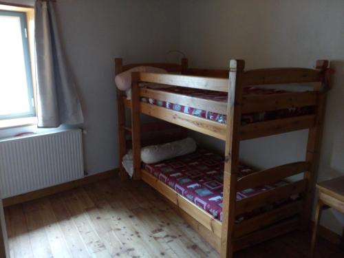 two bunk beds in a room with a window at Ferme Racine in Jausiers
