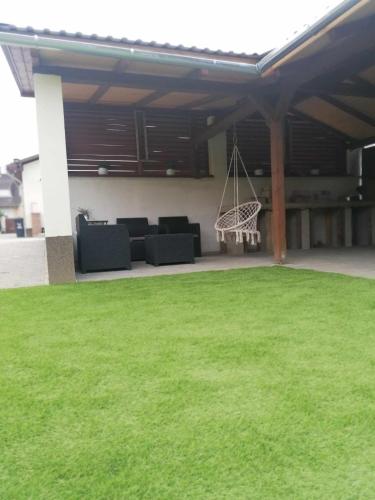 a patio with green grass and a swing at VÁR-LAK Apartman in Kisvárda