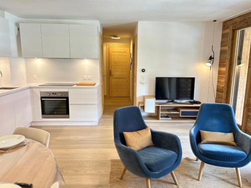 un salon avec deux chaises bleues et une table dans l'établissement Superbe duplex central avec accès Spa, terrasse et parking - FR-1-623-288, aux Gets