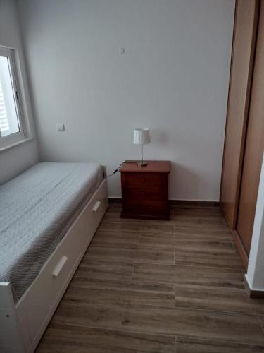 a bedroom with a bed and a lamp on a table at Casa Baptista in Vila do Bispo