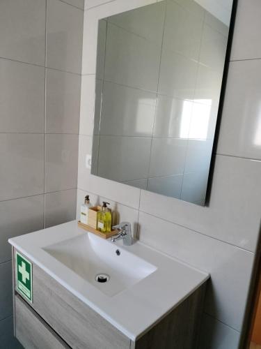 a bathroom with a white sink and a mirror at Casa Baptista in Vila do Bispo