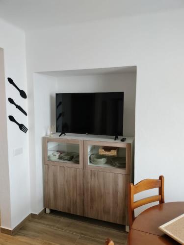 a entertainment center with a flat screen tv on a wall at Casa Baptista in Vila do Bispo