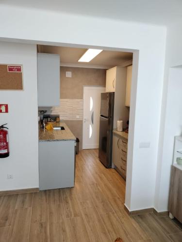 a kitchen with white cabinets and a wooden floor at Casa Baptista in Vila do Bispo