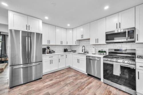 una cocina con armarios blancos y electrodomésticos de acero inoxidable en Comforting Retreat Near Woodfield Mall home, en Rolling Meadows