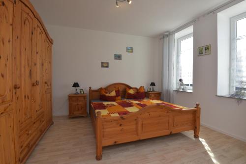 a bedroom with a wooden bed and a window at Ferienwohnungen Sonneberg in Sonneberg