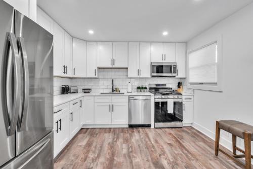 a kitchen with white cabinets and stainless steel appliances at Comforting Retreat Near Woodfield Mall home in Rolling Meadows