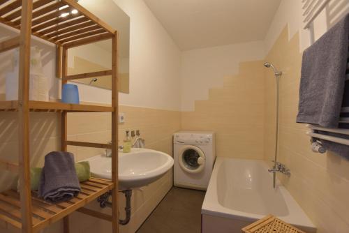 a bathroom with a sink and a washing machine at Ferienwohnungen Sonneberg in Sonneberg