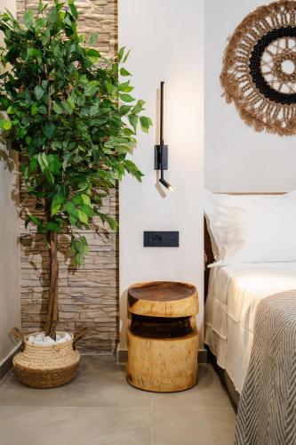 a bedroom with a bed and a wooden stool next to a tree at Legato Spa Suites in Naxos Chora