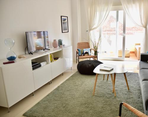a living room with a tv and a couch at Charming 3 Bedroom Apartment Close to Historic Center-Lagos in Lagos