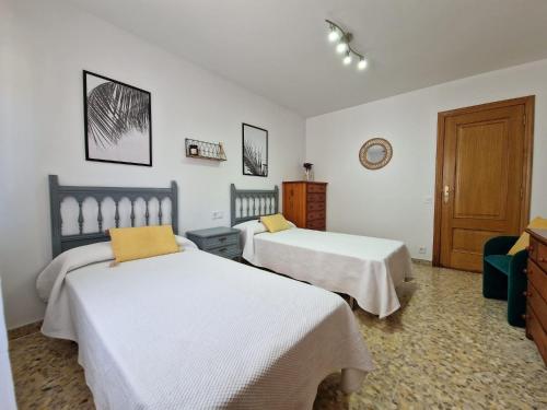 1 Schlafzimmer mit 2 Betten und einer Holztür in der Unterkunft Acogedor alojamiento en Sanxenxo in Sanxenxo