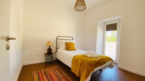 a bedroom with a bed with a yellow blanket on it at OceanLand - Santa Cruz in Santa Cruz