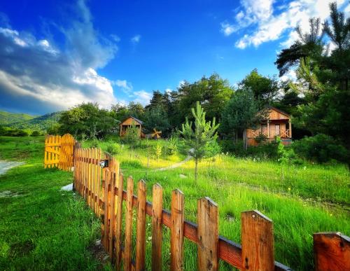 a wooden fence in a field with houses in the background at Eco Park Resort in Stepanavan Dendropark in Gyulagarak
