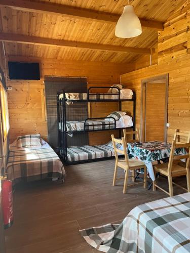 a room with two bunk beds and a table and chairs at Granja escuela con Bungalows in San Martín de la Vega