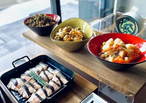 una tavola ricoperta di ciotole di cibo su un tavolo di APA Hotel Kanazawa Katamachi EXCELLENT a Kanazawa