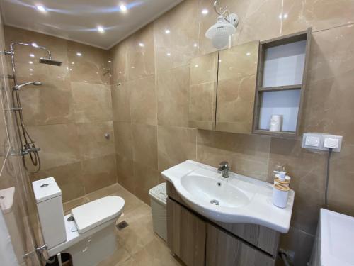 a bathroom with a sink and a toilet and a shower at Batis Breeze Suites in (( Filaréton ))