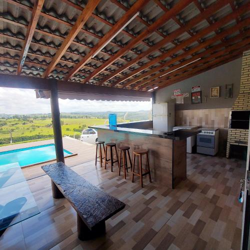 a kitchen with a counter and a bar with stools at Chácara do Mirante in São Sebastião do Paraíso