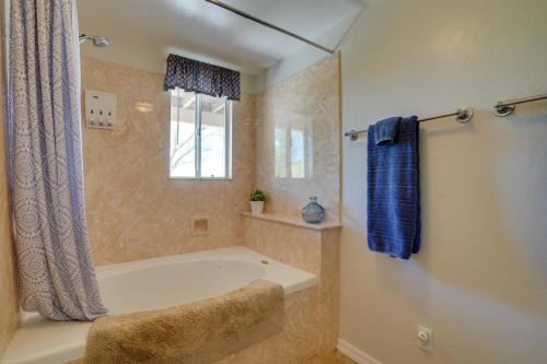 a bathroom with a bath tub and a window at Updated Tucson Home with Panoramic Mtn Views and Pool! in Tucson