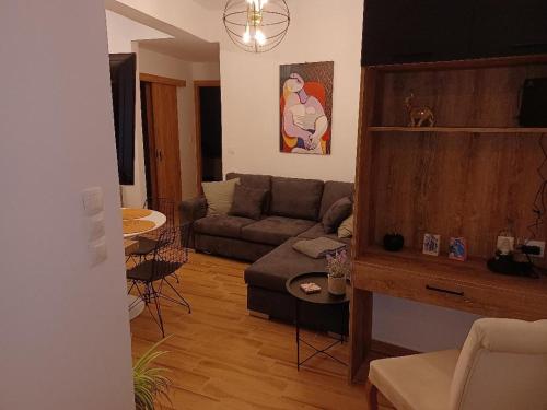 salon z kanapą i stołem w obiekcie kirkis apartment w mieście Ágios Rókkos