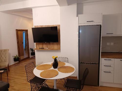 y cocina con mesa, sillas y nevera. en kirkis apartment en Ágios Rókkos