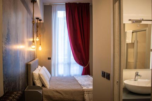 a bedroom with a bed and a sink and a window at Splendid Room Suites in Turin