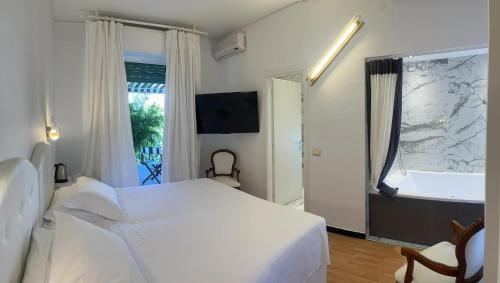 um quarto com uma cama branca e uma janela em Eveline 2 - Piscina Privata o Jacuzzi em Sanremo