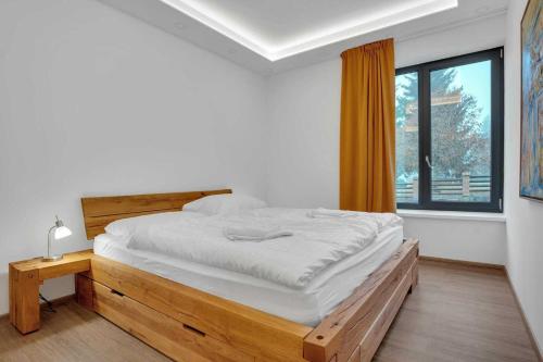 Un dormitorio blanco con una cama grande y una ventana en SKI Apartmán Snowcat en Abertamy