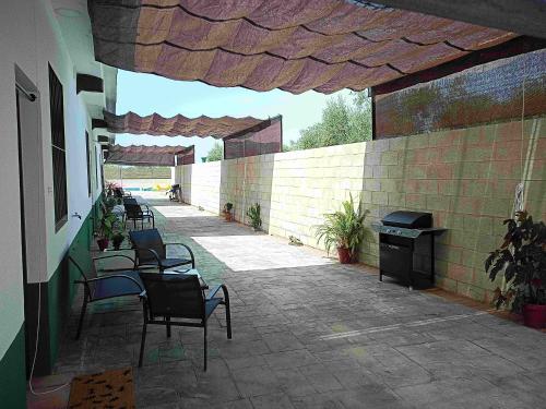 eine Terrasse mit Stühlen und einem Grill auf einem Gebäude in der Unterkunft Alojamiento rural Barroso Alcobendas in La Puebla de los Infantes
