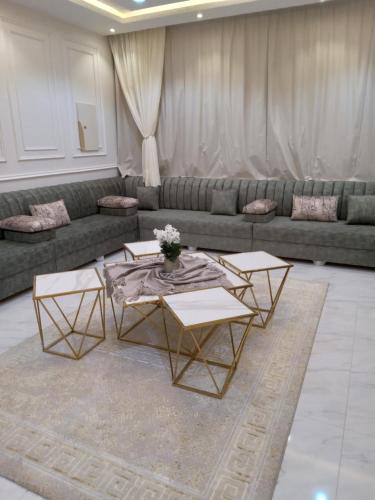 شاليه لوسيل في خميس مشيط: غرفة معيشة مع أريكة وطاولتين