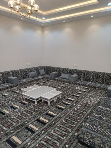 une salle de conférence avec une table et des chaises sur un tapis dans l'établissement شاليه لوسيل, à Khamis Mushait