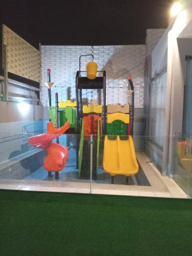 una sala de juegos con un parque infantil con equipamiento colorido en شاليه لوسيل, en Khamis Mushayt