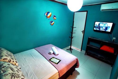 a bedroom with a bed and a tv in a room at Pousada Casa Guntzel in Juquei