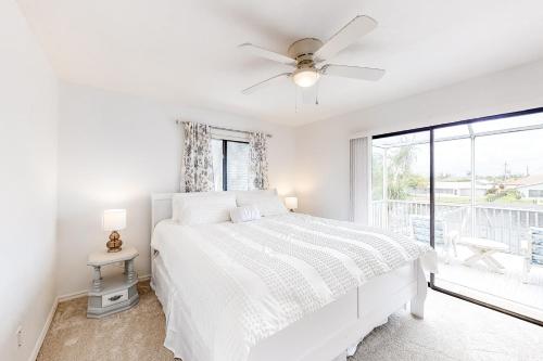 ein weißes Schlafzimmer mit einem Bett und einem Fenster in der Unterkunft Creating Memories by the Canal in Cape Coral
