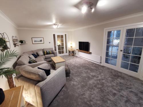 a living room with a couch and a tv at La de da Frinton on Sea in Frinton-on-Sea