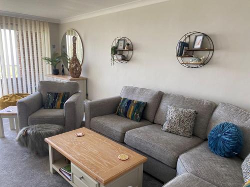 a living room with a couch and two chairs at La de da Frinton on Sea in Frinton-on-Sea